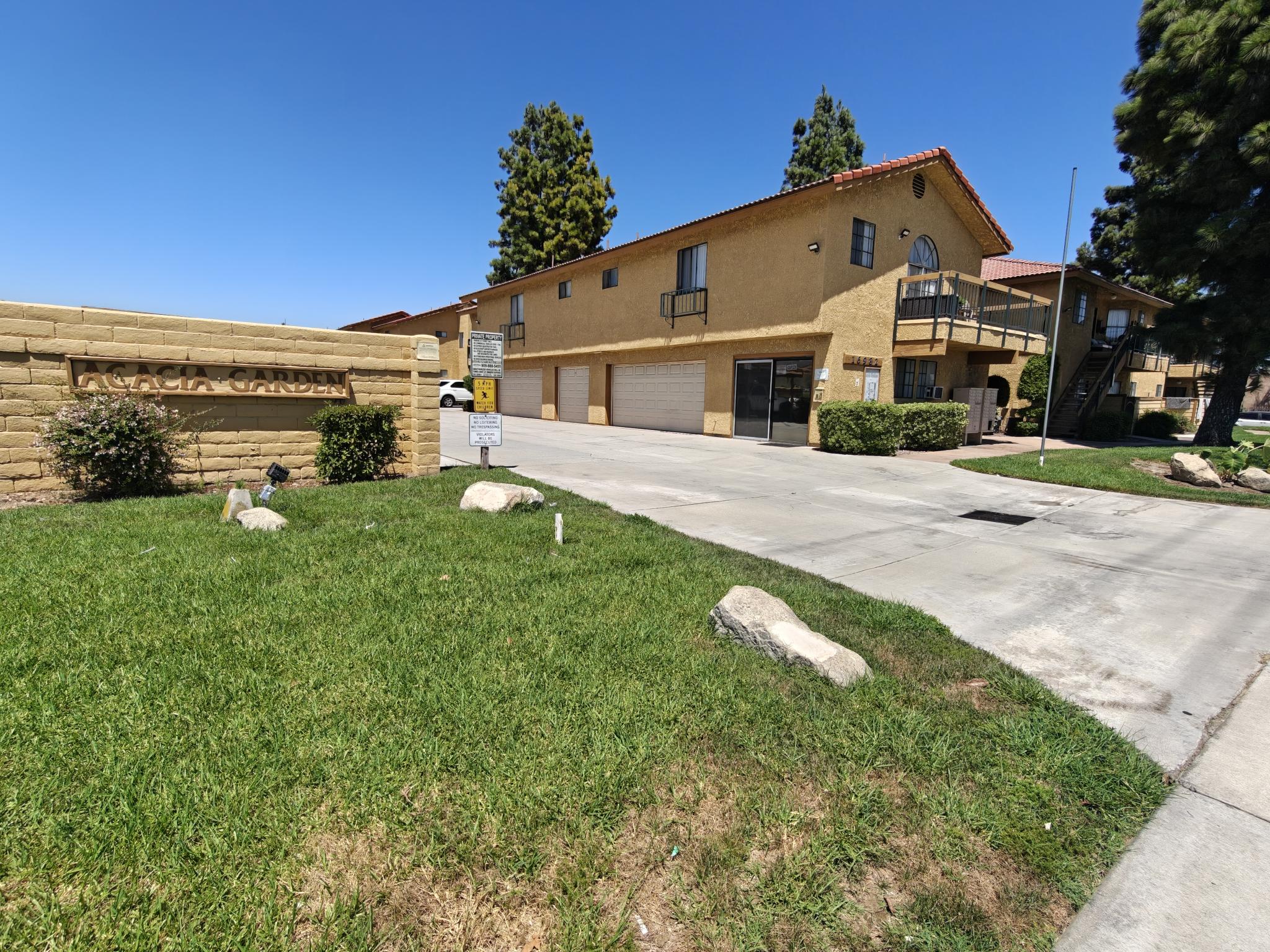 A yellow house with a garage and a driveway in front.